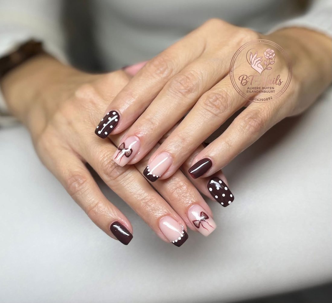 Chocoladebruine en nude nagels met witte stippen en strikjes