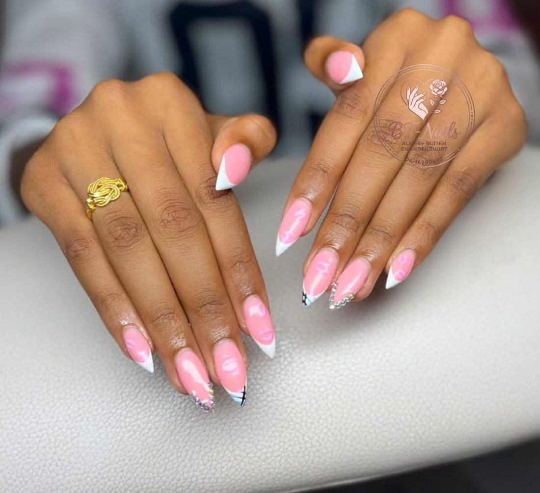 Roze stiletto nagels met witte French tips, kusjes en steentjes